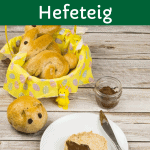 Hefehasen, Osterhasen aus Hefeteig, zwei Hasen in einem Korb und ein Hasenbrötchen auf einem Teller aufgeschnitten, mit gesunder Schokocreme bestrichen