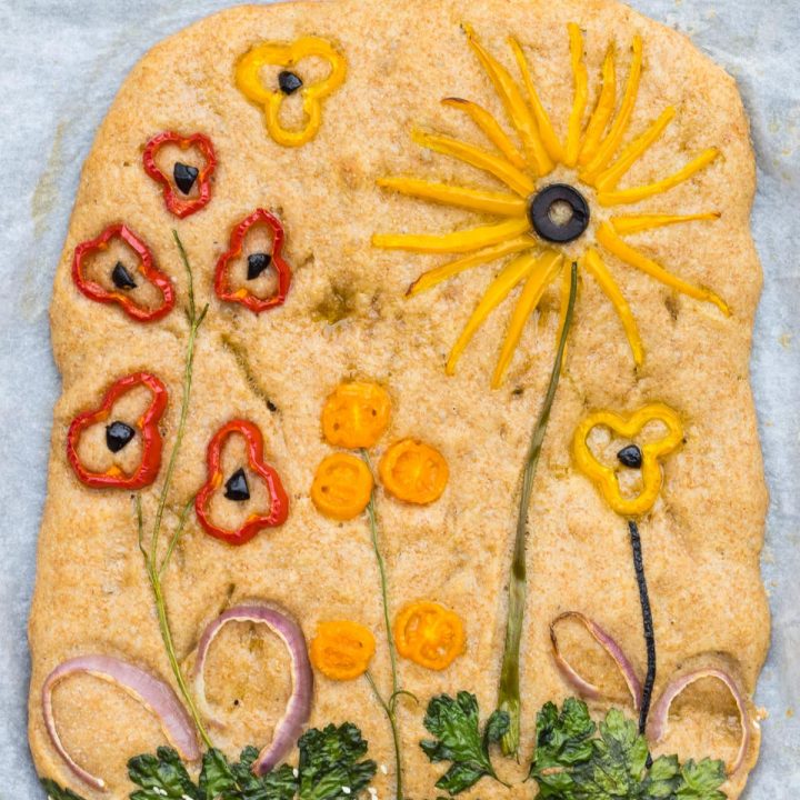 Focaccia Fladenbrot mit Blumen verziert, aus Gemüse und Kräutern