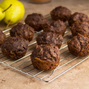 Saftige Schokoladenmuffins mit Birne, auf einem Kuchenrost ausgebreitet zum Abkühlen