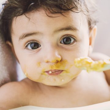 Baby das mit Brei gefüttert wird