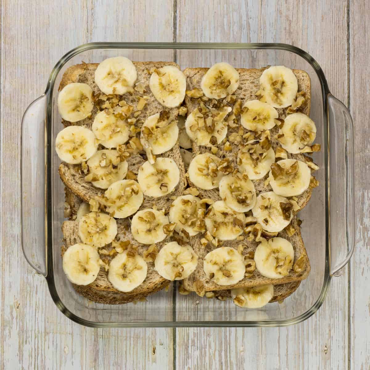 altbackenes Brot, Banane und Nüsse in einer Auflaufform um Brotauflauf mit Banane zu machen