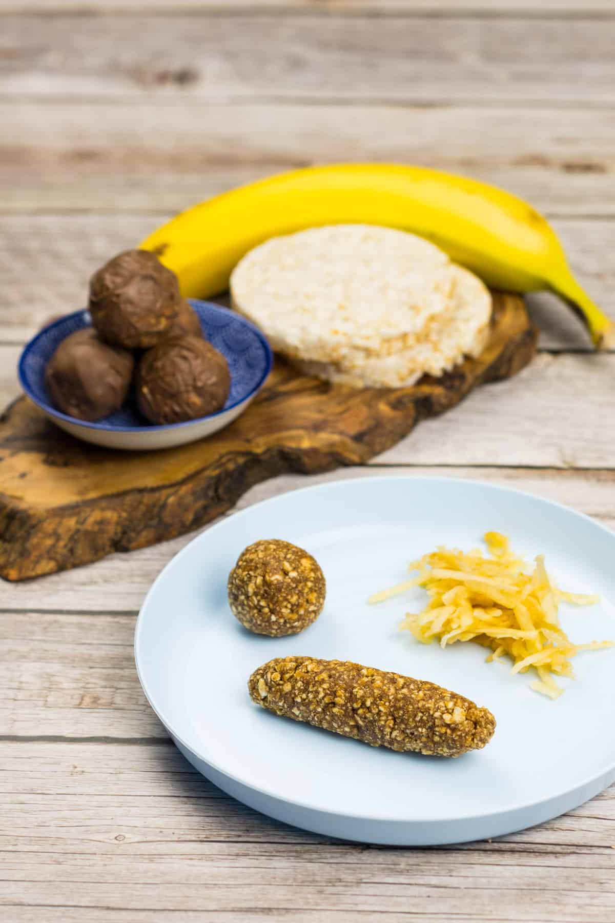 Babysnack aus Reiswaffel, auf einem Teller mit geriebenem Apfel