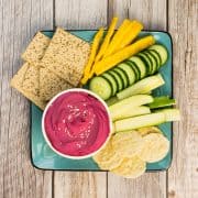 Rote Beete Hummus Dip in einer Schale, mit Gemüse und Crackern zum Dippen