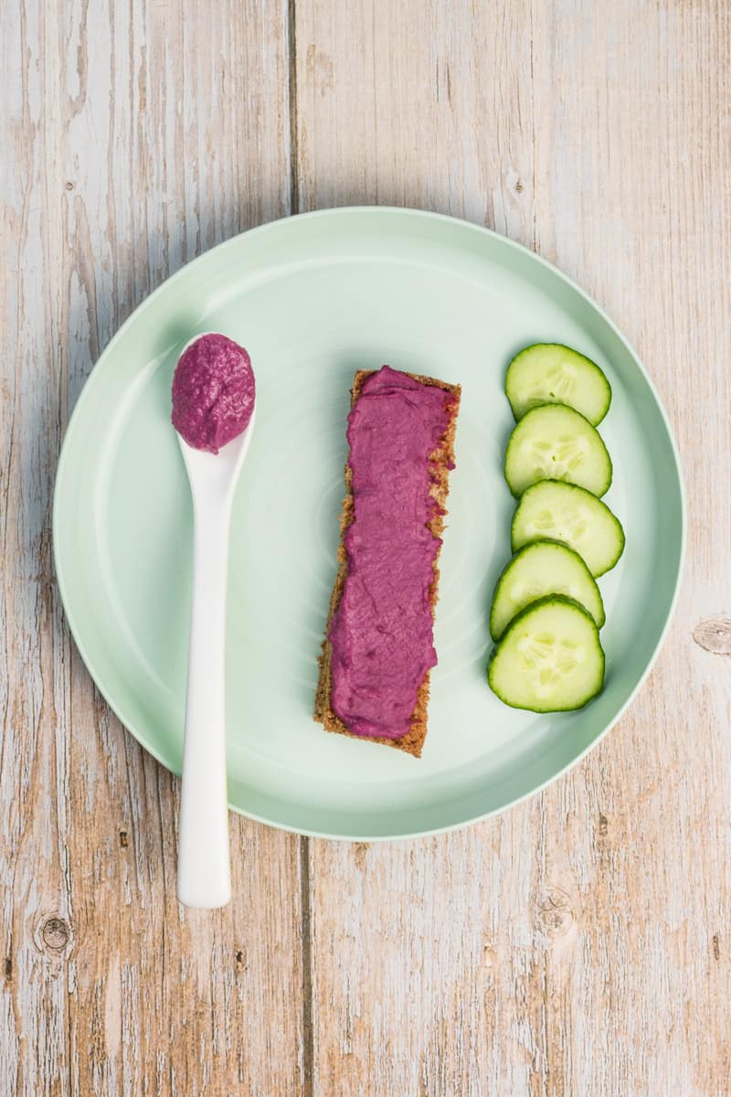 Rote Beete Hummus für Babys, auf Brot geschmiert und auf einem Babylöffel zum selber Essen