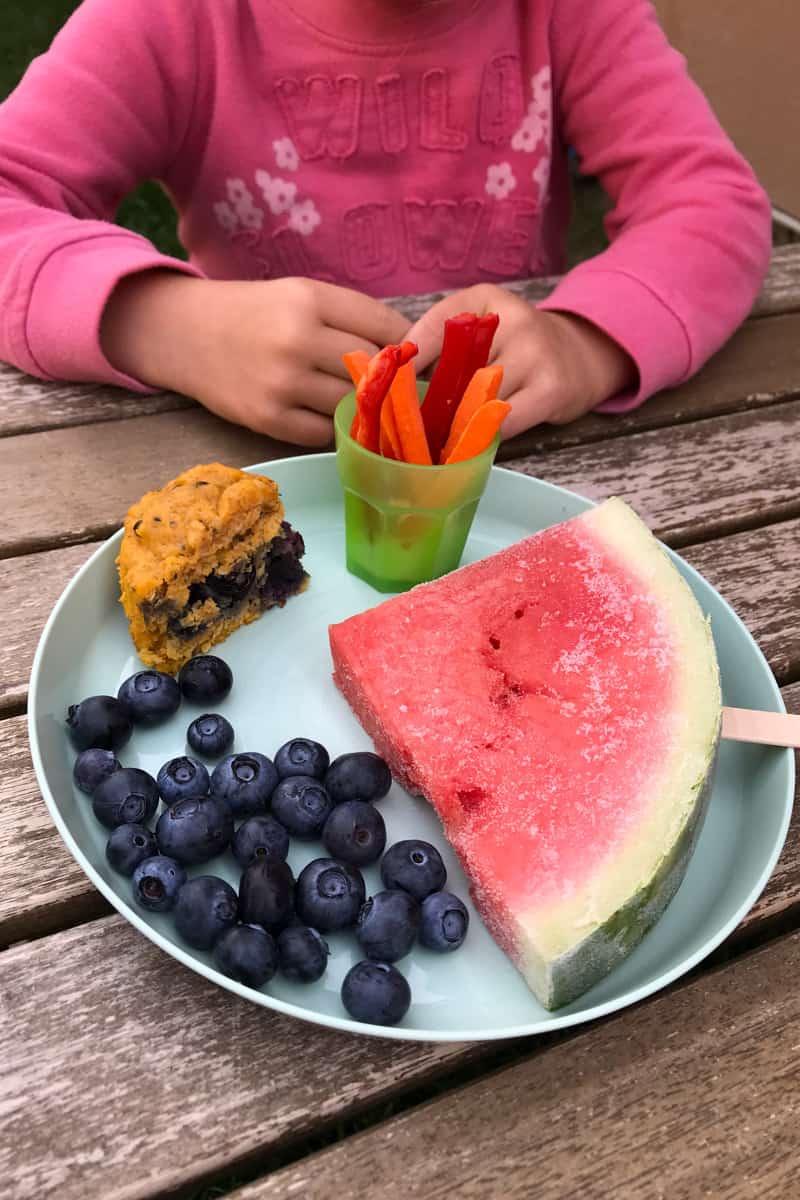 Wassermelone am Stiel, auf einem Teller, mit Blaubeeren und anderen Snacks