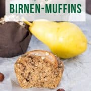 Saftiger Birnen-Muffin mit Haselnussmus, auf einem Holzbrett, mit Birnen und Haselnüssen