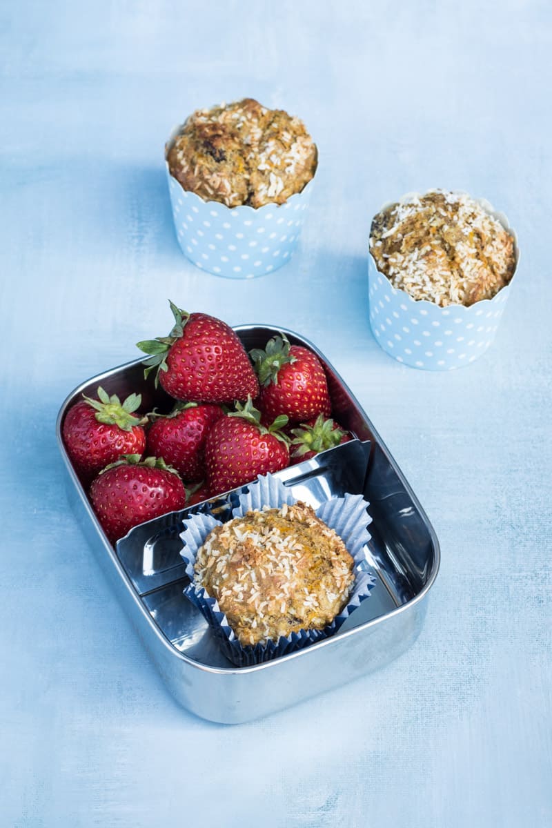 Gesunder Frühstücksmuffin in einer Brotdose mit Erdbeeren dazu