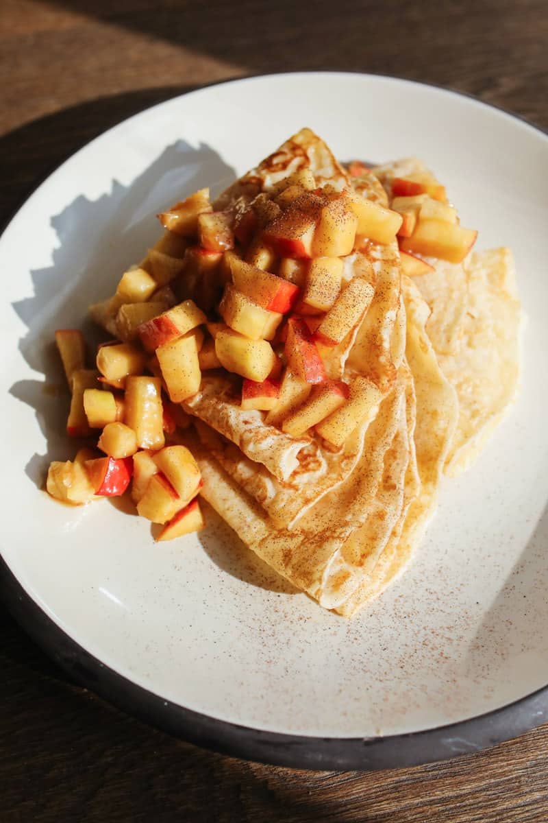 Pfannkuchen mit Apfelstücken und Zimt, auf einem Teller