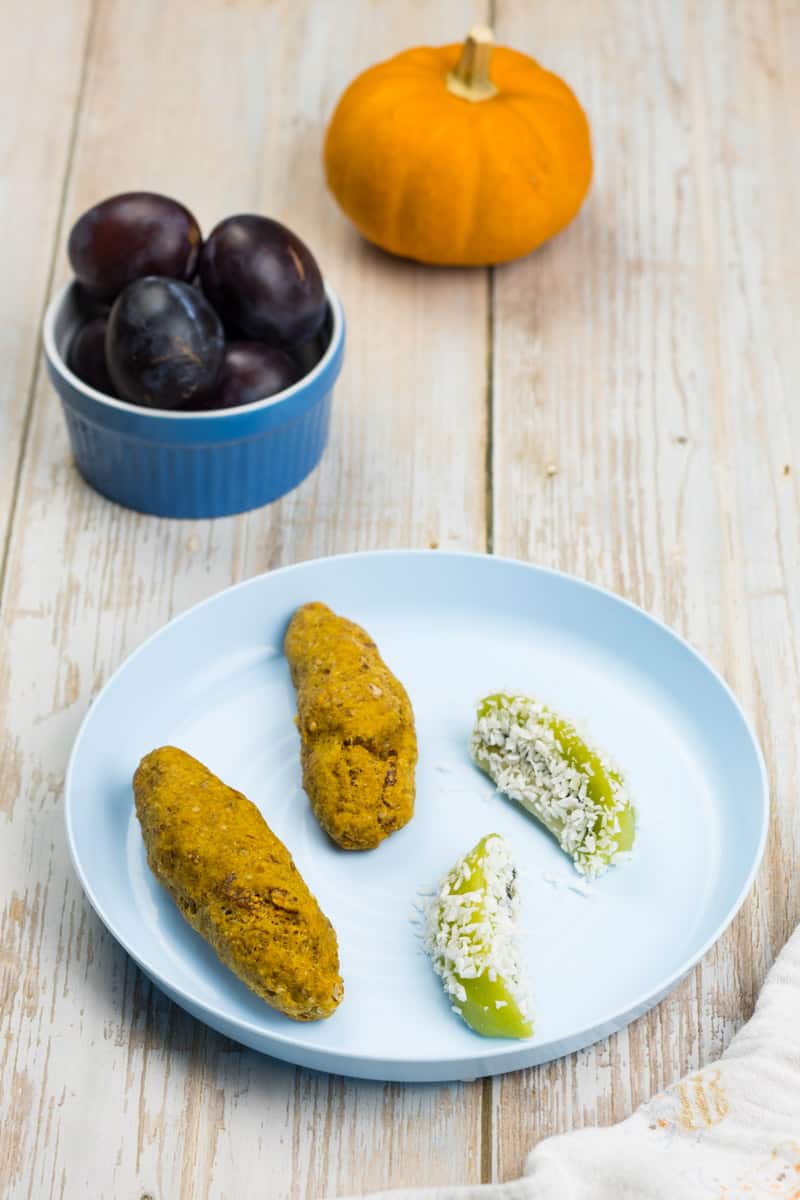 Vegane Scones mit Kürbis, auf einem Babyteller, mit in Kokosraspeln gewälzten Kiwi-Spalten