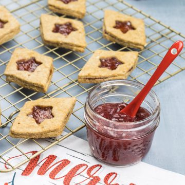 Einfache und gesunde Marmeladenkekse, auf einem Kuchenrost, mit einem Glas Marmelade daneben