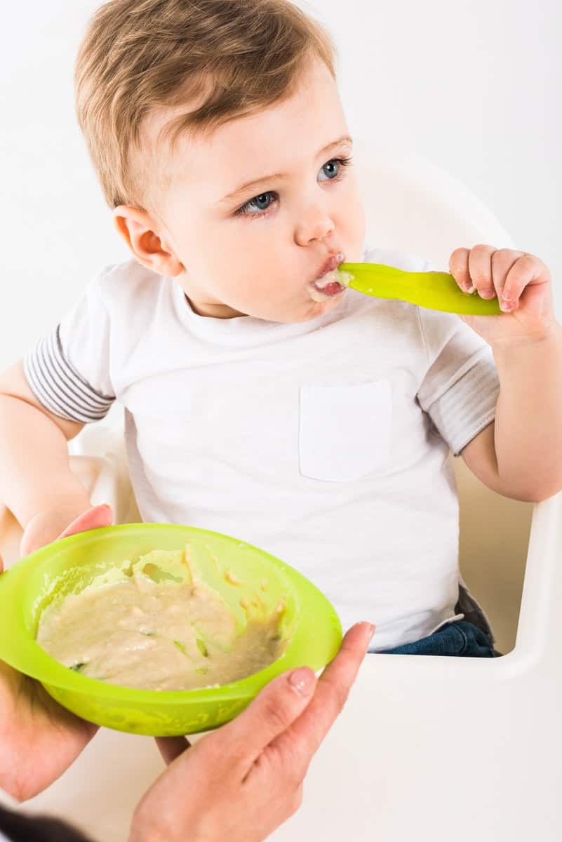 Baby ist Babybrei selber mit einem Löffel