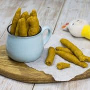 zuckerfreie Dinkelstangen mit Süßkartoffel für Babys, in einem Becher, auf einem Holzbrett