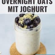 Overnight Oats mit Joghurt, sowie Blaubeeren und Hanfsamen als Topping, in einem Glas