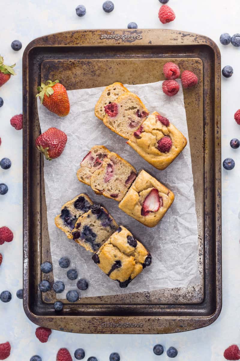 Zuckerfreies Bananenbrot für Babys, auf einem Backblech, drei Varianten, mit Blaubeeren, mit Erdbeeren und mit Himbeeren