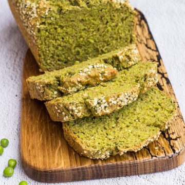 Grünes Erbsenbrot mit viel Gemüse, aufgeschnitten auf einem Holzbrett